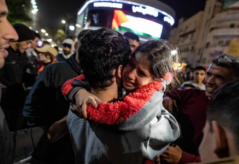 A girl hugs a newly released Palestinian prisoner in Ramallah in the occupied West Bank on Sunday [Fadel Senna/AFP]