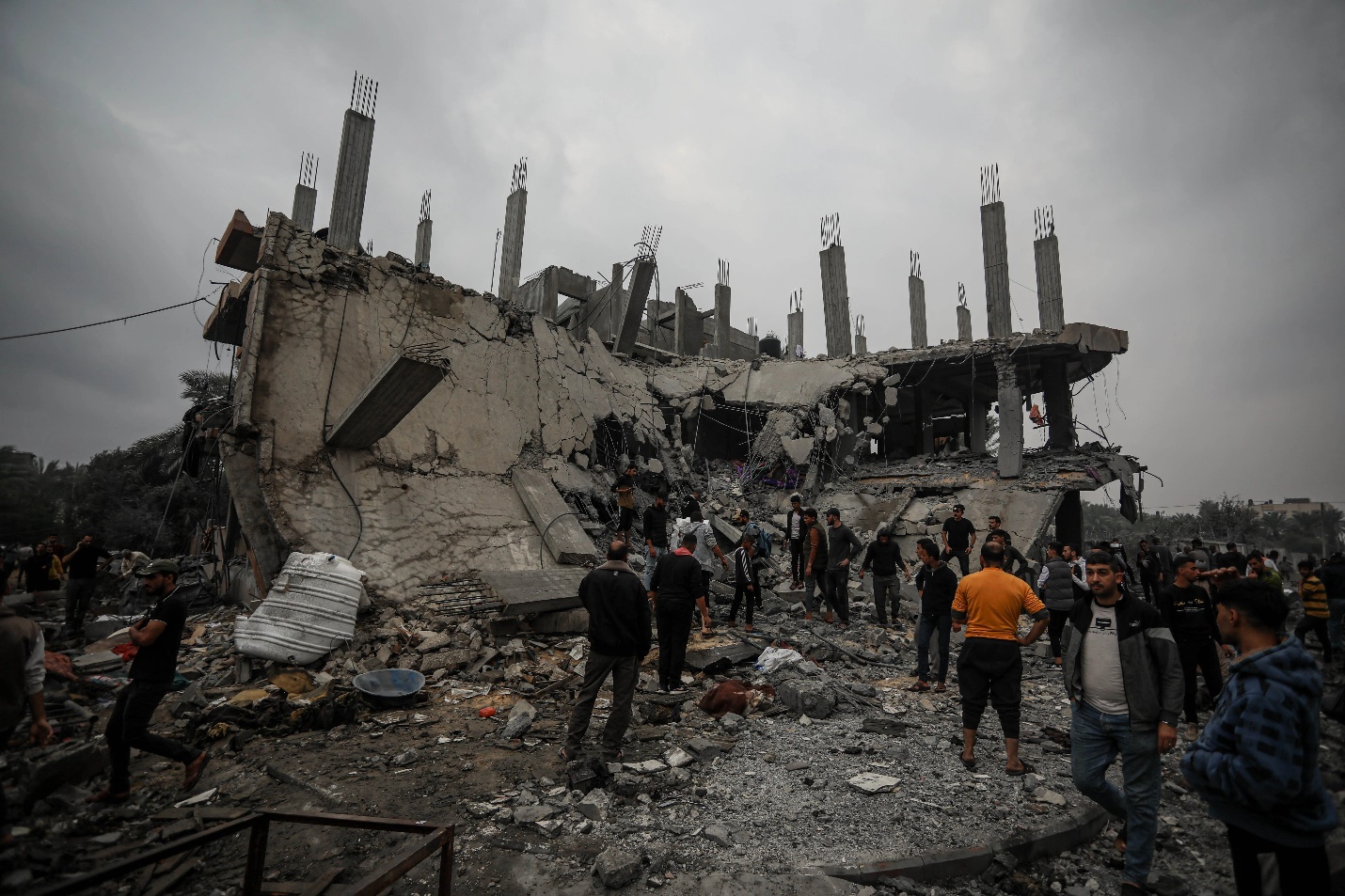 Locals and rescue teams look for survivors in ruined Abu Musbih building in Deir al-Balah [Abdelhakim Abu Riash/Al Jazeera]