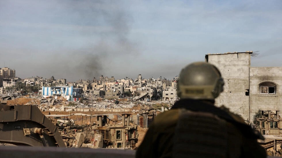 An IDF soldier looks over the devastating aftermath of an Israeli air raid in Gaza on January 8th, 2024 [Ronen Zvulun/Reuters]
